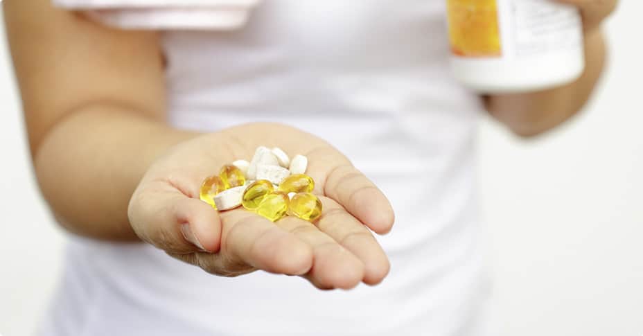 Woman Holding Hand full of Vitamins — MedSurg Weight Loss in Brisbane, QLD