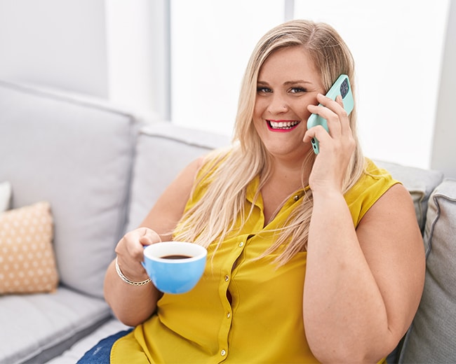 Woman using her phone while drinking coffee — MedSurg Weight Loss in Brisbane, QLD