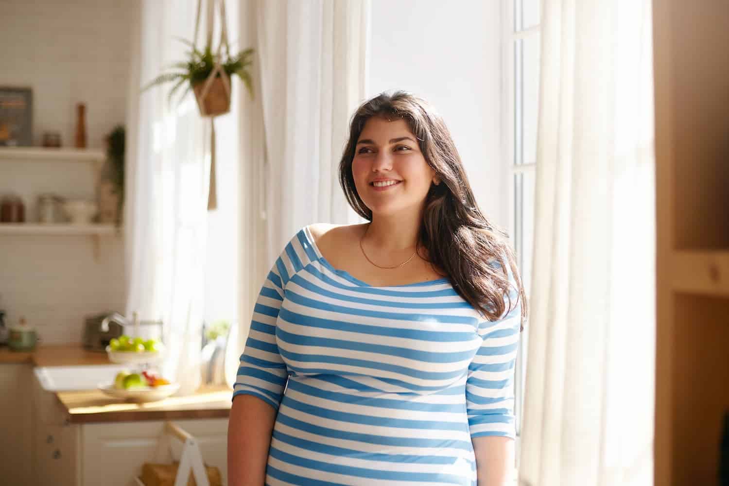 Woman in a blue and white striped dress standing in a kitchen — MedSurg Weight Loss in Brisbane, QLD